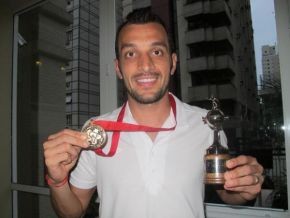 Edu Dracena mostra a medalha e a réplica da Taça Libertadores.(Imagem:Adilson Barros/Globoesporte.com))