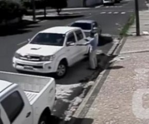 Criminoso desce de outro veículo e aponta a arma para a dona do carro.(Imagem:Reprodução)