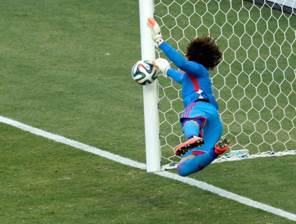 Ochoa busca no canto, perto da trave, a bola cabeceada por Neymar.(Imagem:AP)