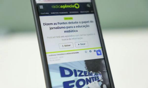 Celular com imagem da página do podcast, Dizem as Fontes da Radioagência Nacional da EBC.(Imagem:Tomaz Silva/Agência Brasil)