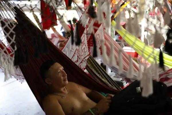 O designer gráfico Weucles Santos, do Movimento Garantido, dorme em rede no barco em que navegou até Parintis para torcer pelo Boi Garantido no 57º Festival Folclórico de Parintins(Imagem:Fernando Frazão/Agência Brasil )
