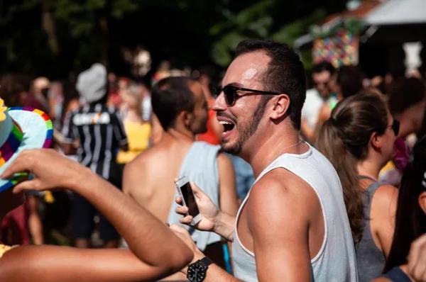  Homem usa celular durante desfile de bloco de carnaval.(Imagem:Marcelo Brandt/G1 )