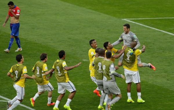 Julio C&eacute;sar &eacute; abra&ccedil;ado pelos companheiros ap&oacute;s a vit&oacute;ria.(Imagem:AP.)