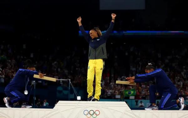 Norte-americanas Simone Biles (&agrave; esquerda) e Jordan Chiles reverenciam Rebeca Andrade ap&oacute;s brasileira conquistar medalha de ouro no solo nos Jogos de Paris 2024.(Imagem:REUTERS/Hannah Mckay/Proibida reprodu&ccedil;&atilde;o)