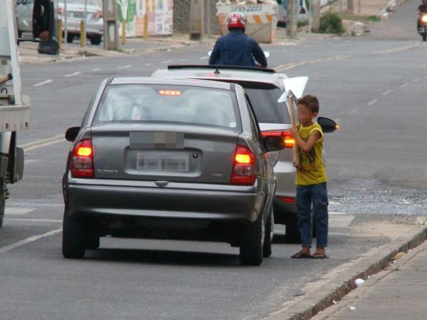 Crianças vendem objetos e pedem esmolas em semáforo da Zona Leste