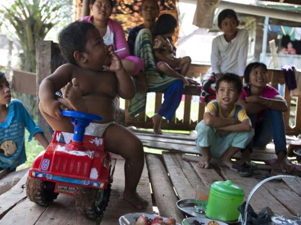 Aldi SugandaRizal, de 2 anos, &eacute; visto fumando cigarro enquanto brinca com parentes em 23 de maio, em Sekayu, distrito de Sumatra, na Indon&eacute;sia (Imagem:Barcroft)