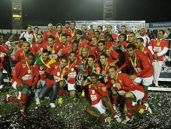 Jogadores da Portuguesa posam ao lado da ta&ccedil;a de campe&atilde; da S&eacute;rie B.(Imagem:Ag&ecirc;ncia Estado)