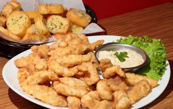  Por&ccedil;&atilde;o de til&aacute;pia do H2 Chopp: fil&eacute; de til&aacute;pia aperitivo &agrave; dor&ecirc;, acompanha molho t&aacute;rtaro e torradas na manteiga.(Imagem: Divulga&ccedil;&atilde;o )