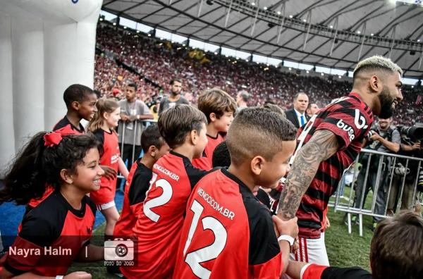 Com a pequena Alice e outras sorridentes crian&ccedil;as, Gabigol entra em campo para jogar partida que encaminhou o hepta do Flamengo.(Imagem:Nayra Halm/Foto do Jogo )