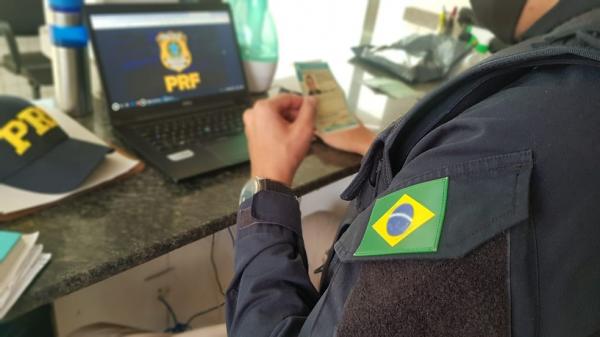 Agente da PRF analisa CHN falsa encontrada com homem.(Imagem:PRF/Divulga&ccedil;&atilde;o)