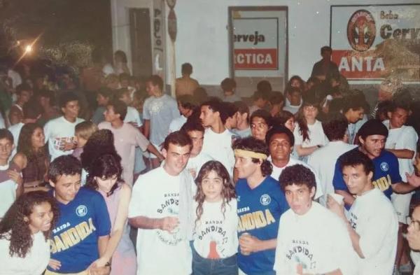  Bloco Banda Bandida em Teresina na d&eacute;cada de 80, no centro da imagem, abra&ccedil;ados na mulher est&atilde;o o rep&oacute;rter Tino Marcos de camisa branca e &Uacute;ltimo Coelho, de camisa azul e faixa ama(Imagem: Arquivo Pessoal / Ant&ocirc;nio Fernandes )