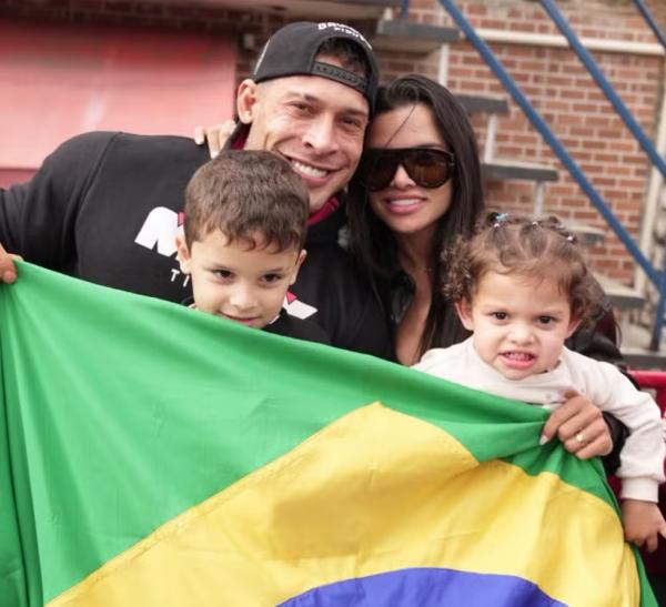 Ramon Dino é recebido com festa em retorno ao Brasil e desfila em carro aberto