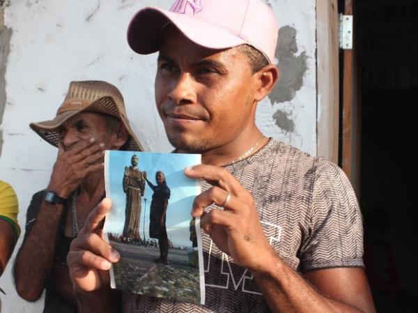 Pedro Vin&iacute;cius segura a foto da av&oacute;, uma das v&iacute;timas da chacina.(Imagem:Catarina Costa)