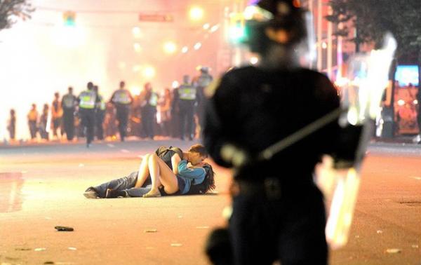 Scott Jones e Alexandra Thomas se beijam no asfalto durante tumulto, na foto que teve repercuss&atilde;o em todo o mundo.(Imagem:Rich Lam/Getty Image)