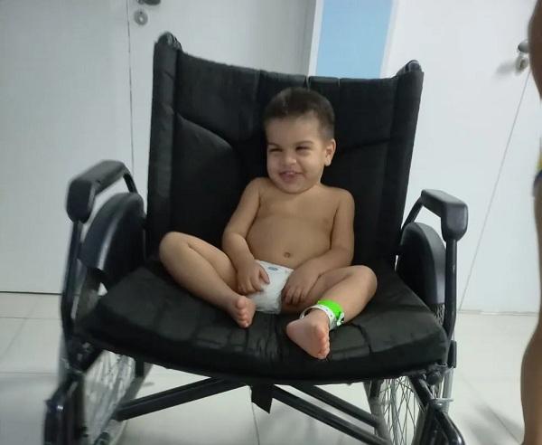  Th&eacute;o na cadeira de rodas durante interna&ccedil;&atilde;o no hospital.(Imagem:Arquivo Pessoal / Suzany Ferreira )