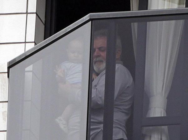 Lula com uma crian&ccedil;a na sacada do apartamento onde mora, em S&atilde;o Bernardo.(Imagem:Marcos Alves / Ag&ecirc;ncia O Globo)